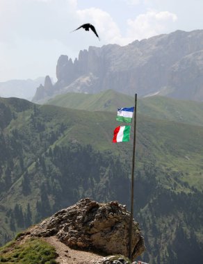 İtalya bayrağı ve Ladinia bayrağı Kuzey İtalya 'nın Dolomites dağ sırasındaki Alp bölgesi karga ile