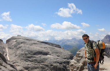 Yaz boyunca İtalya 'nın kuzeyindeki Avrupa Alpleri' nin Dolomites dağlarındaki Sasso Pordoi dağlarında sırt çantalı genç bir yürüyüşçü.