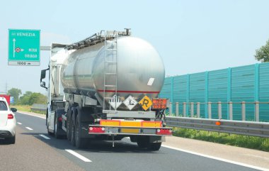 fuel tanker speeding toward refueling stations and highway noise barriers on the road clipart