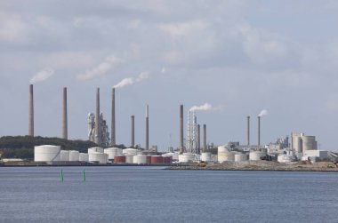 Deniz kenarında bacaları, yakıtı ve gaz depolama tankları olan sanayi bölgesi.