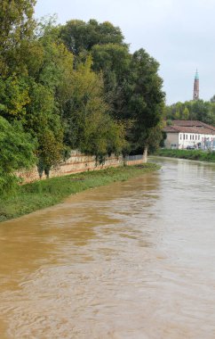 retaining wall along the riverbank during flood caused by torrential rains clipart