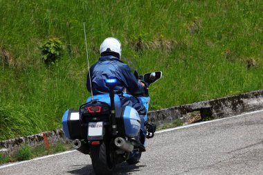 Treviso, TV, Italy - May 25, 2024: Armed Italian police officer on a motorcycle patrolling the city streets clipart