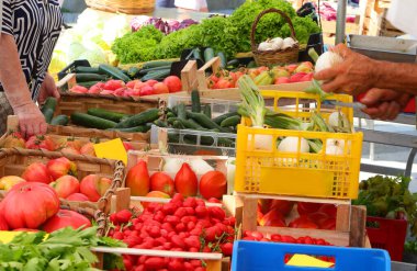 Marketteki sebze ve meyve kasalarıyla manavdaki insanların kolları.