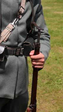 Birinci Dünya Savaşı 'ndan kalma eski bir tüfeği elinde tutan üniformalı askerin tarihi canlandırması.