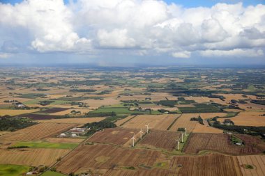 Ovanın manzarası, ekili tarlaları ve yukarıdan görülen birçok rüzgar türbini var.