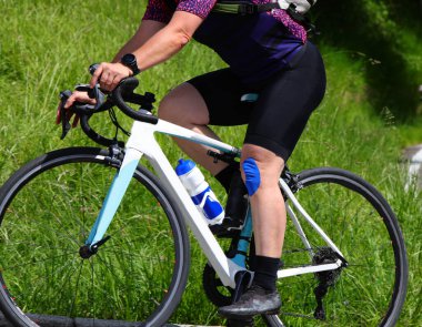 Dizi bandajlı bir kadın bisiklet yarışında bisiklet sürüyor.