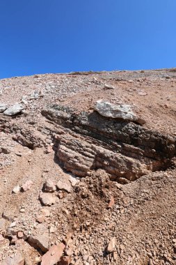 Aşağıdan bakıldığında dağ heyelan içinde demir mineralleri nedeniyle birçok kırmızı kaya görülür.