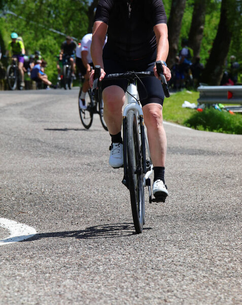 велосипедист с педалями для гонок в гору на асфальтированной дороге, во время велогонки