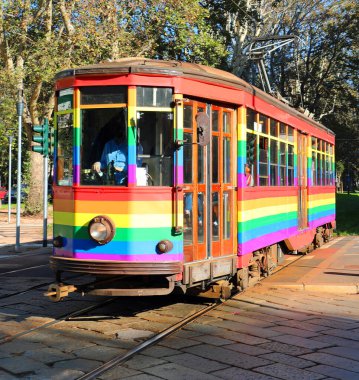 Şehrin gökkuşağı renklerine boyanmış raylarda eski moda elektrikli tramvay.