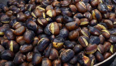 Sonbahar sokak yemeği olarak ideal kömürleşmiş derili bir sürü kavrulmuş kestanenin arka planı