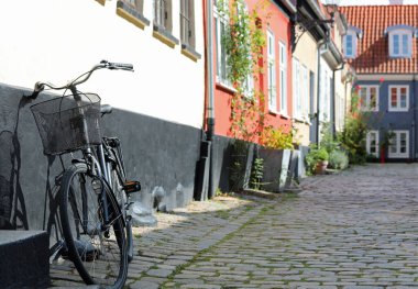 Old bicycle against the wall of a house in the narrow alley of Northern Europe clipart