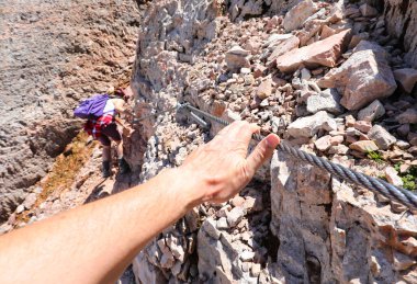 Yazın neredeyse 3000 metre yükseklikteki bir dağ yolunda Ferrata 'nın çelik kablosunu sıkıca kavrayan bir elle zorlu bir geçit.