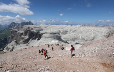 many people walking down the steep trail in the Italian Alps within the Dolomite mountain range during summer clipart