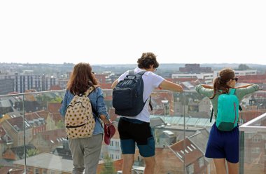 Annesi, oğlu ve kızıyla birlikte turist ailesi şehir manzarasına bakıyor.