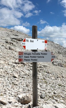 Arrows on the sign indicating the mountain trail to reach the peaks of the Dolomites in the Alps in Europe during summer clipart