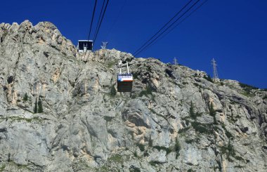 İnsanları ve malları çok güçlü çelik kablolar ve kayalık bir dağ duvarıyla yüksek irtifaya taşımak için hava tramvayı.