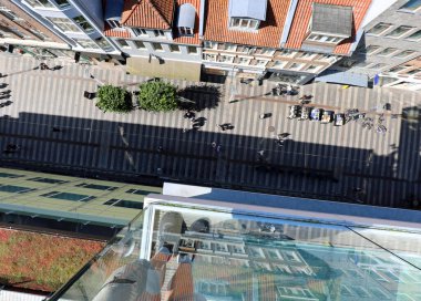 Şehir merkezinde dükkanları ve insanları olan bir yaya caddesinin hava görüntüsü.