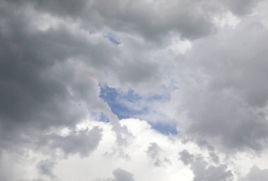 Mavi gökyüzüne bir göz atmak, gri ve siyah bulutların arasında yağmuru tehdit etmek.