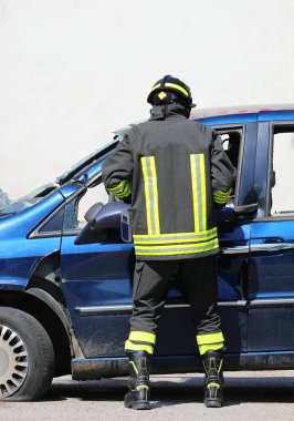 İtfaiyeci çarpışmadan sonra yaralıları kurtarmak için çarpışan bir arabanın metalini kesmek için güçlü hidrolik çene kullanıyor.
