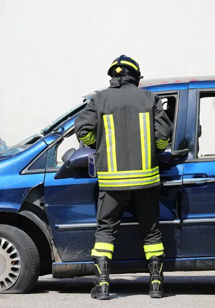 İtfaiyeci çarpışmadan sonra yaralıları kurtarmak için çarpışan bir arabanın metalini kesmek için güçlü hidrolik çene kullanıyor.
