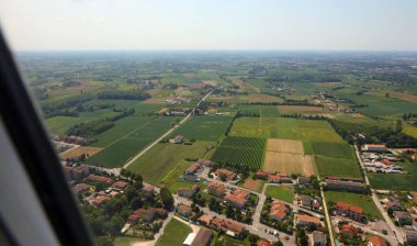 Bir ev uçağının penceresinden hava manzarası ve yukarıdan ekilmiş tarlalar.