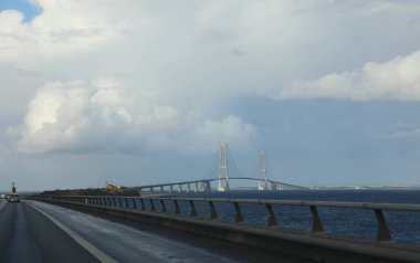 long road and bridge called storebaeltsbroen in northern denmark in europe clipart