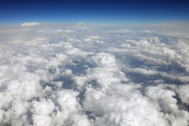 Kıtalararası yolculuk sırasında uçan bir uçağın penceresinden beyaz bulutların anlamlı görüntüsü