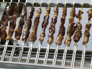 Restoranda dönen ve hareket etkisine neden olan bir sürü arrosticini şişleri var.