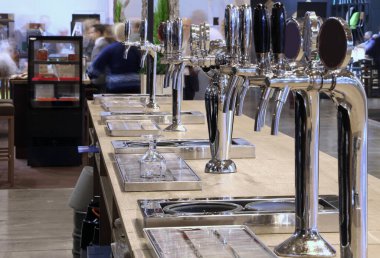 Metalik çelik musluklu modern bar tezgahı müşterilere taze bira ve diğer içecekler dağıtmak için.