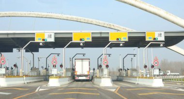 Geçiş ücreti için otoyolun sonundaki modern gişede bir kamyon durdu.