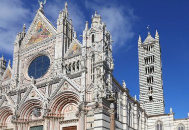 Gothic style Duomo facade and bell tower in Siena in the Tuscany Region in Central Italy clipart