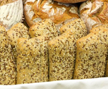 Bir sürü somun ekmekli sepet sepetinde susam tohumları ve diğerleri.