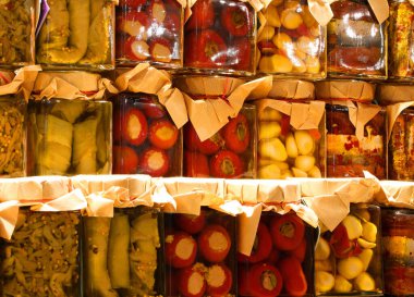 Biber ve ançüez gibi korunmuş yiyeceklerin tezgahında yağda korunmuş ya da satılmaya bırakılmış pek çok yiyecek var.