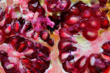 Lezzetli olgun nar makro fotoğraf, sulu tohumlar ve vitamin açısından zengin kırmızı posa.