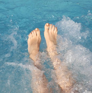 woman's feet during the hydromassage session in the spa pool clipart