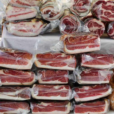 Bir sürü vakumlu ve plastik ambalajlı kurutulmuş et ve jambon pazarda satılıyor.