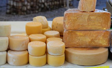 Avrupa 'daki yerel pazarda satılık çeşitli boyutlarda taze ve eskimiş peynir çeşitleri