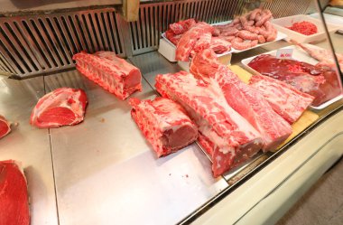 Kasapta bir sürü kırmızı domuz eti, et ve sosis var.