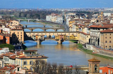 Arno Nehri üzerindeki Ponte Vecchio 'nun havadan görünüşü güneşle ve İtalya' daki diğer tarihi binalarla mükemmel aydınlatılıyor.