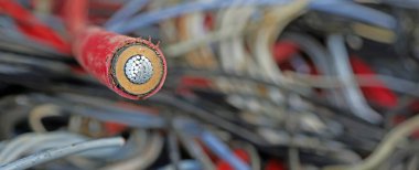 Yüksek gerilimli elektrik kablosunun çok sağlam yalıtımı ve diğer kabloların kasıtlı olarak bulanık arkaplanının kesitindeki ayrıntı
