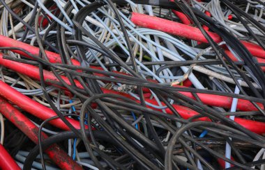 Geri dönüşümlü materyallerin yeniden kullanılması için kullanılan ve geri dönüşüm merkezinde toplanan eski bakır elektrik kablolarının arkaplanı