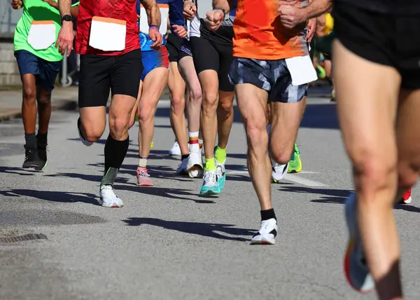 Koşu yarışı sırasında koşucuların bacakları ve tanınmayan yüzler insanlar arasında rekabet ve mücadele kavramı olarak idealdir.