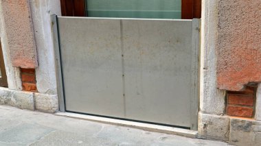 Kuzey İtalya 'da Venedik' teki bir evde denizin yüksek gelgitinden korunmak için çelik kapı.