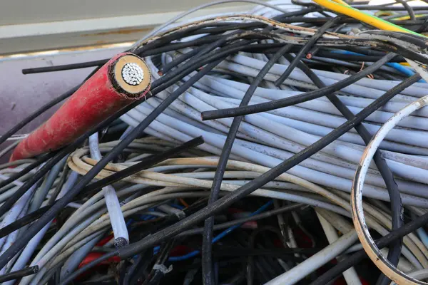 Geri dönüştürülebilir atıkların ayrı bir koleksiyonu için geri dönüşüm merkezinin konteynerinde kullanılan eski elektrik kabloları