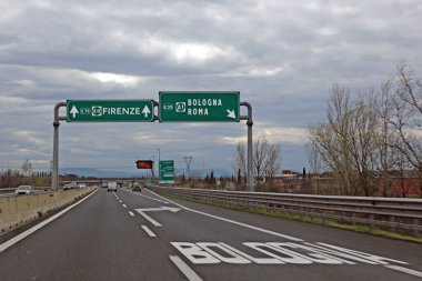 Orta İtalya 'da BOLOGNA FLORENCE ve ROME şehirlerinin yönergeleriyle kavşakta otoyol tabelası bulutlu gökyüzü ile