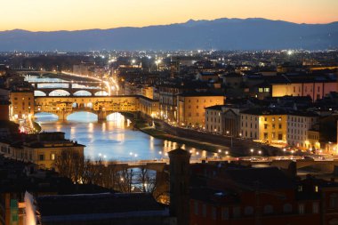 Aydınlatılmış evler, köprüler ve çok geniş Arno nehri ile muhteşem panoramik manzara Floransa şehrinin gece vakti uzun pozlama tekniğiyle fotoğraflandı.