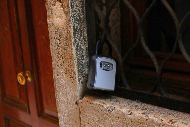 Kiralık dairenin anahtarlarını depolamak için küçük bir konteynır. Evin girişinin yanında açmak için gizli şifre kombinasyonu var.