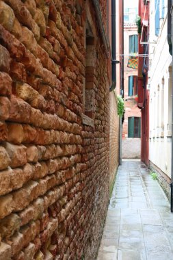 İtalya 'da Venedik Adası' nda duvarları kırmızı tuğlalarla kaplı İtalyan dilinde CALLE adı verilen dar bir sokak.