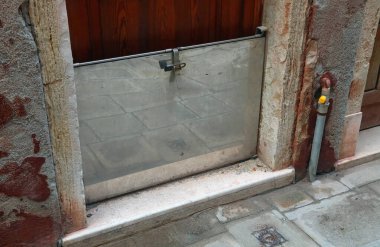 İtalya 'daki Venedik Adası' nda gelgit yükselmesi durumunda evi korumak için paslanmaz stgeel ile yapılmış taşkın kapısı.