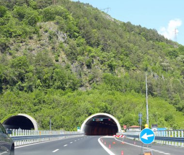 Trafik ışığı ve hız detektörü olan büyük bir otoban tüneli.